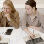 two women with laptops