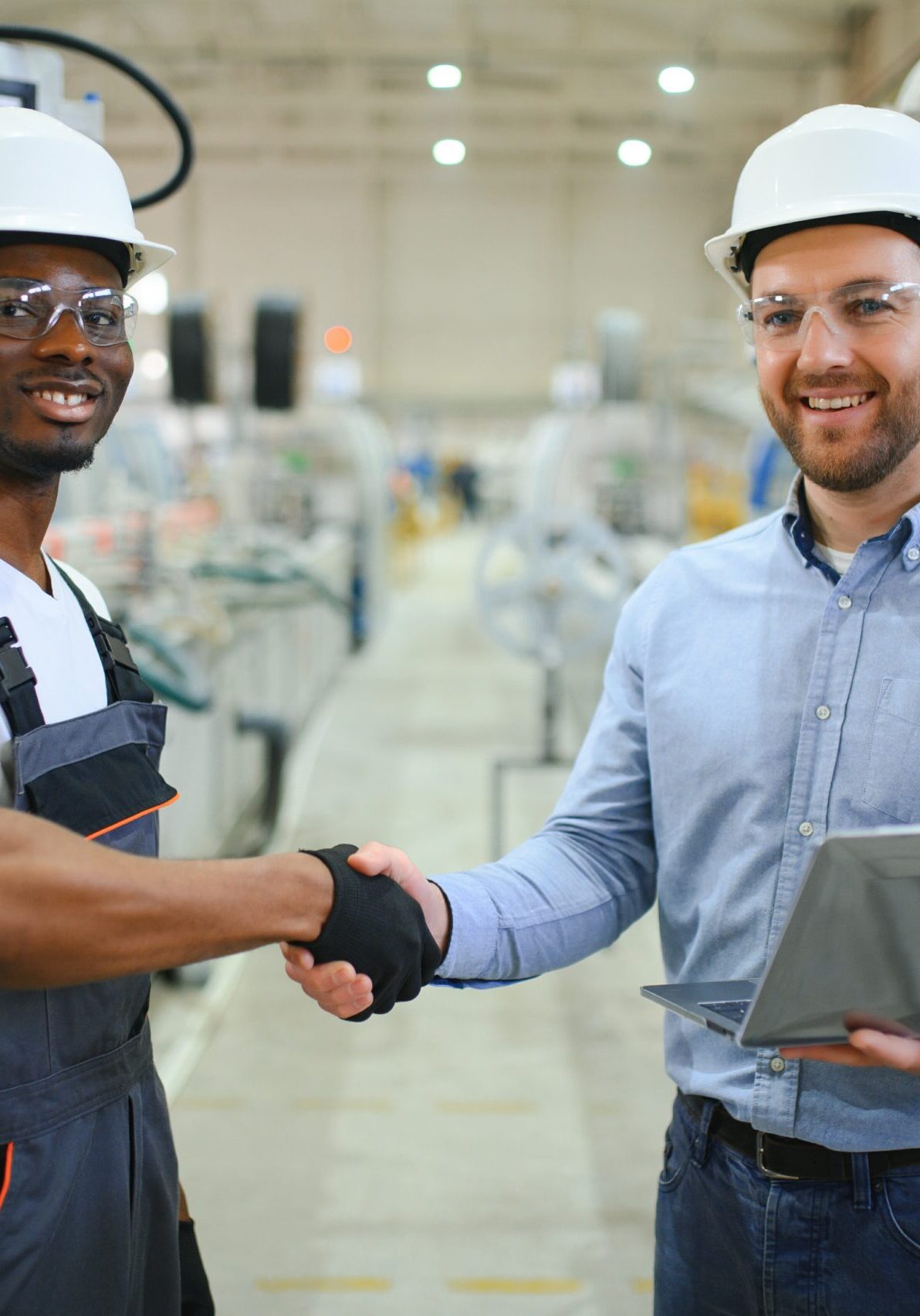 An engineer communicates with a worker on a production line.